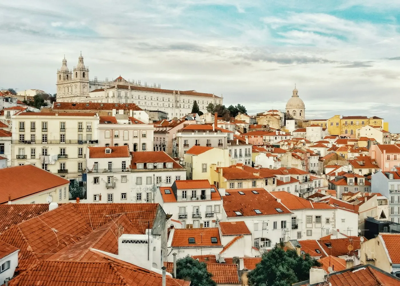 Terracotta rooftops of Lisbon under a clear blue sky